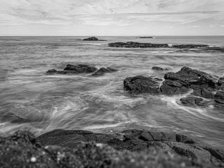 rocks and the ocean are in black and white