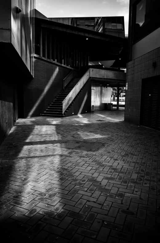 sun shines in between two buildings while shadows hang over them