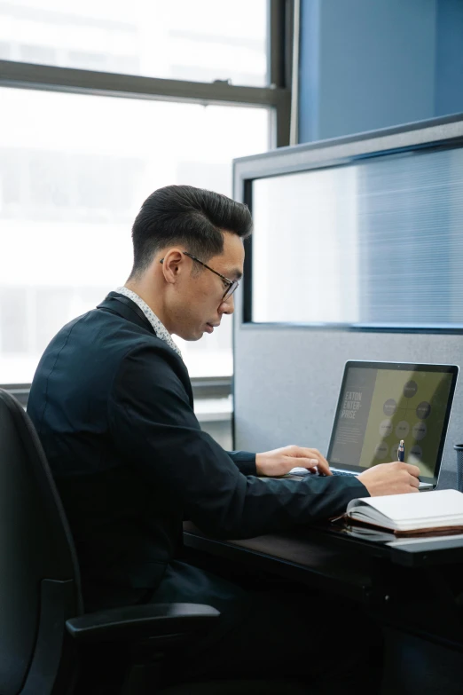 a man sitting at his desk with his lap top computer