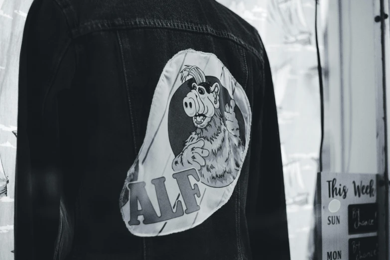 a man wearing a denim jacket with the words ajax in it