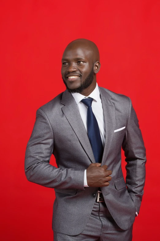 a black man dressed in a gray suit poses for a po