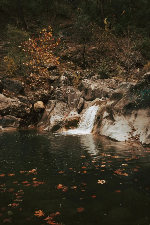 a waterfall flowing down a rocky slope into a lake