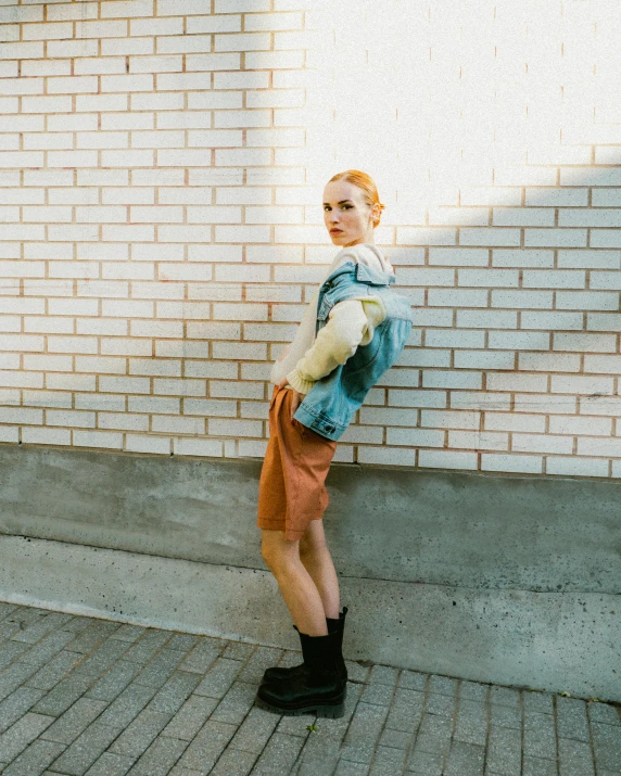 a girl standing on the sidewalk wearing high heels and a coat