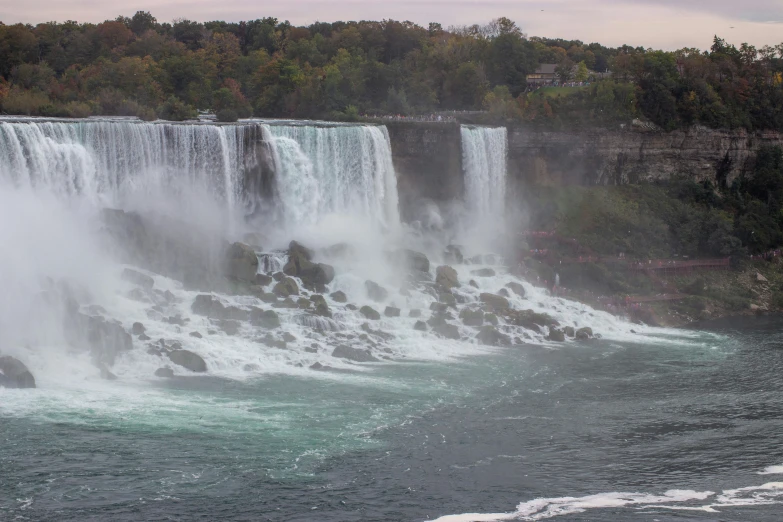 the view from a boat in the water, where a waterfall falls