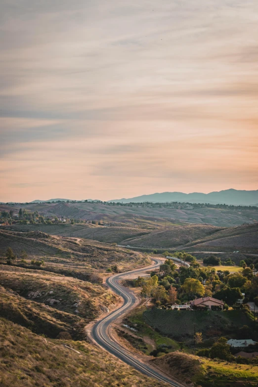 a scenic landscape with the sun shining on the rolling hills