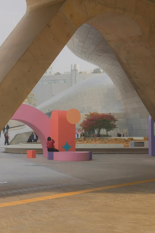 the arches surrounding a building with a man sitting on a bench under it