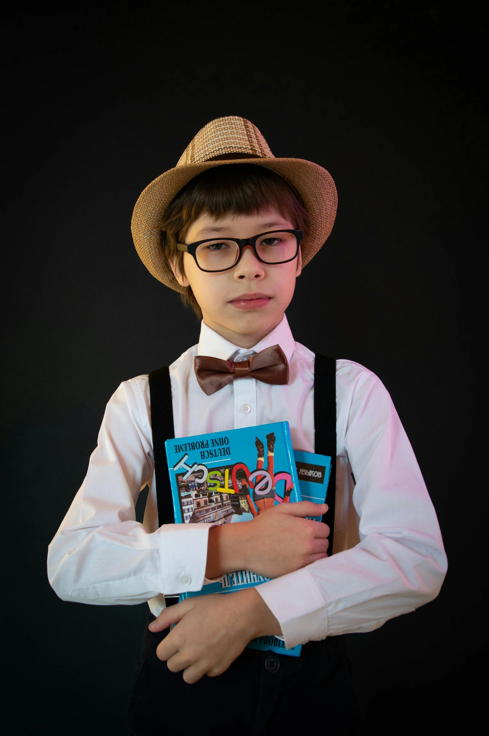 the boy is dressed in all white and is holding a book