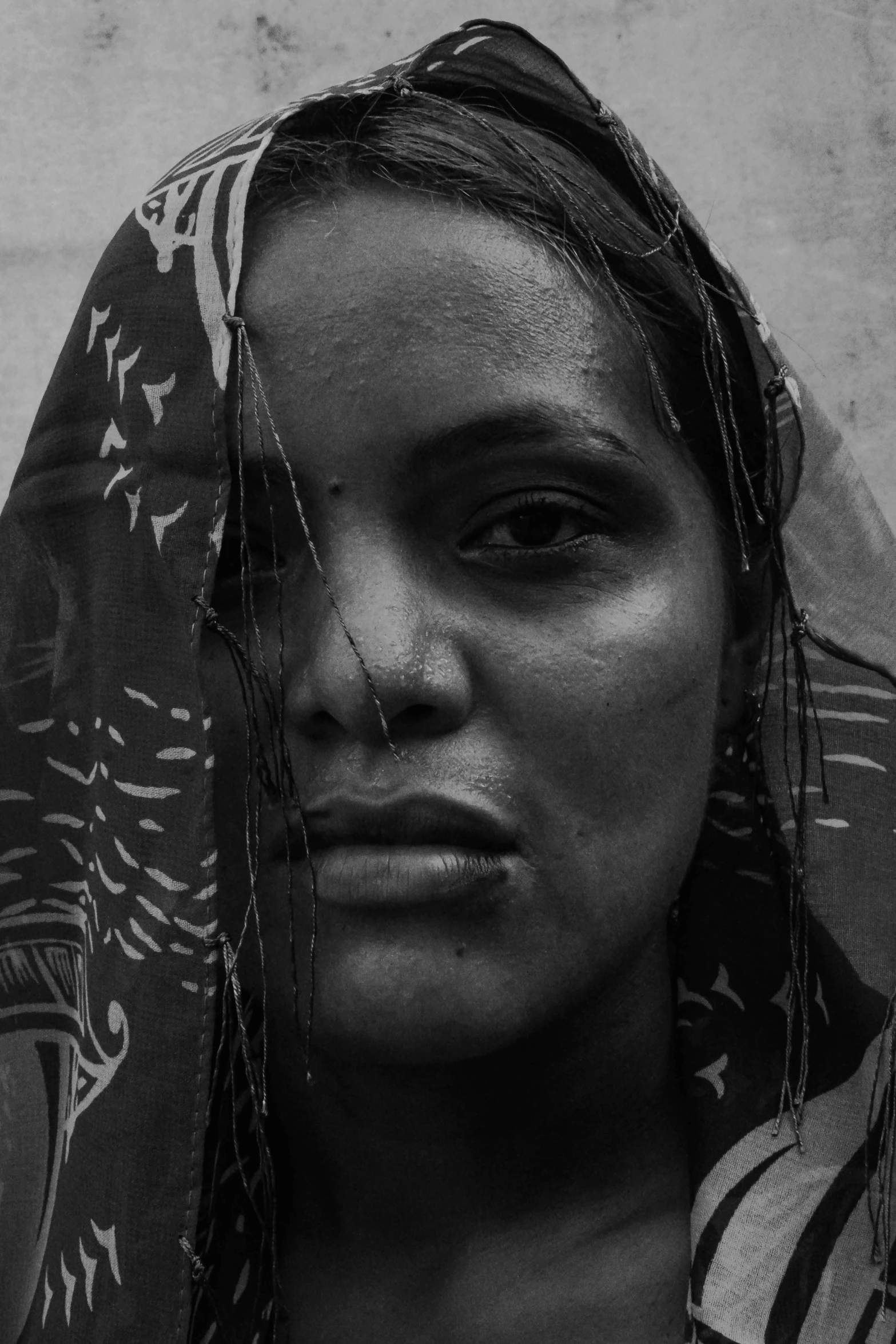 a woman in a shawl stares at the camera