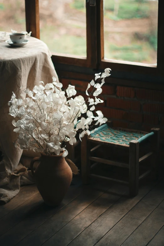 a vase filled with white flowers next to a table