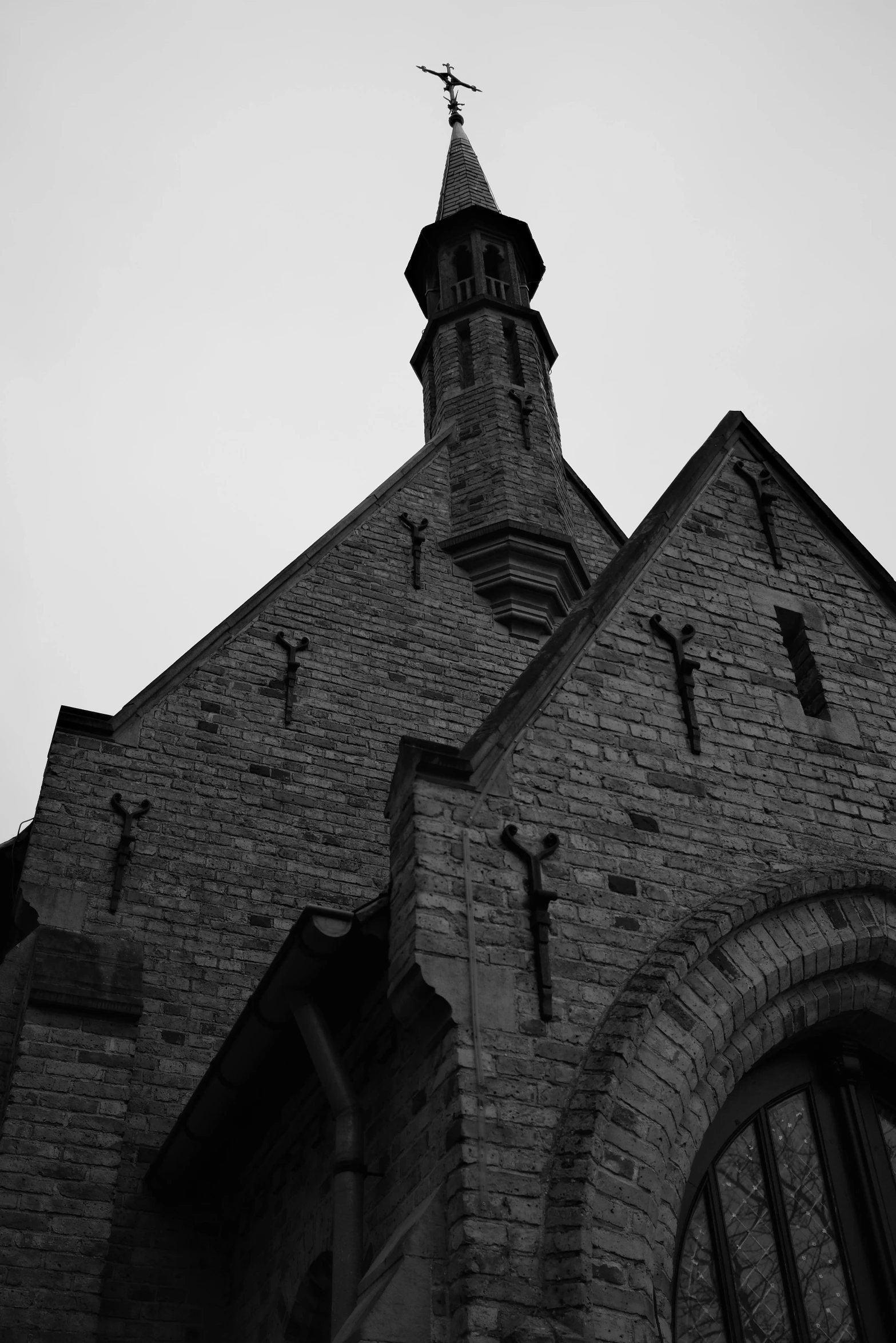 the side of an old gothic church with crosses and window panes