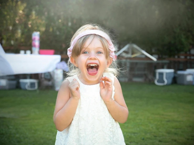 little girl holding an apple with her mouth open