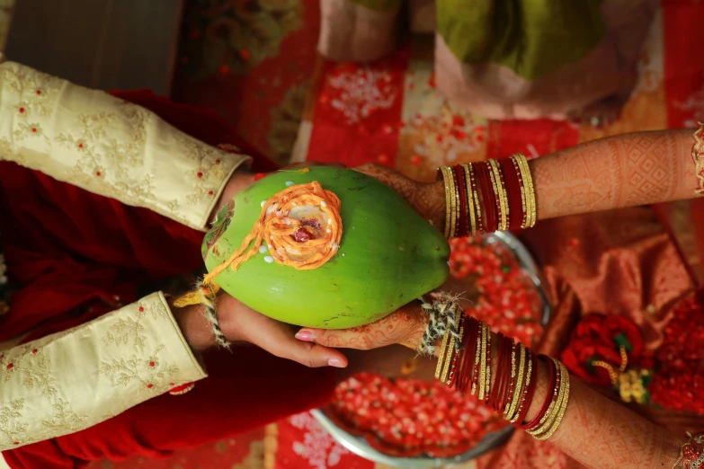 three people holding fruit with many designs on them