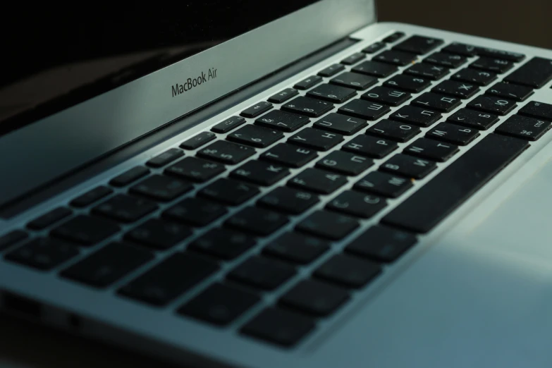 a silver laptop computer sitting on top of a wooden table