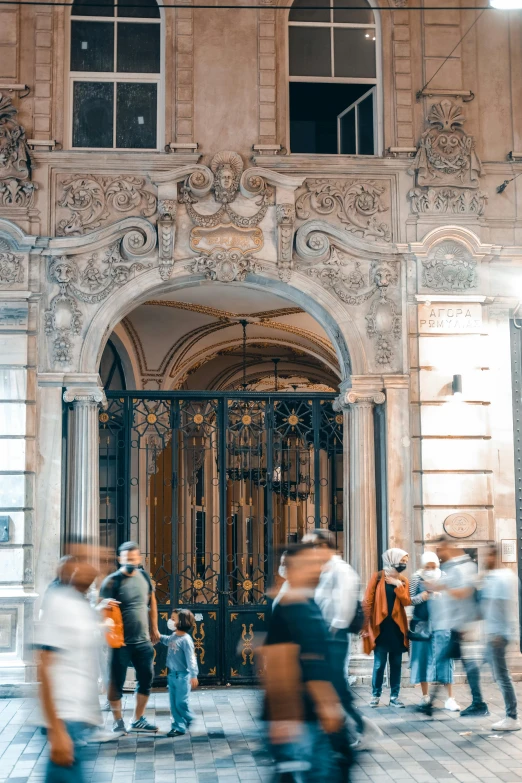 blurred motion image of people walking in front of an ornate building