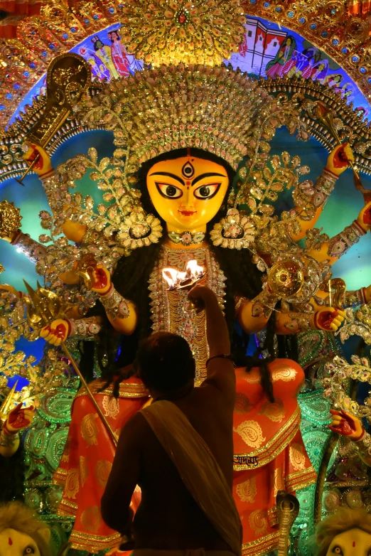 a man is lighting a fire lantern on a statue