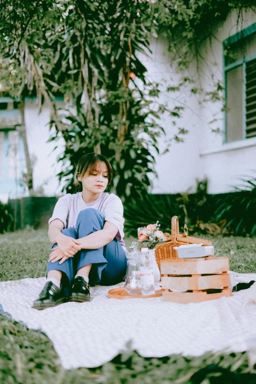 a woman sitting on a blanket holding a bottle