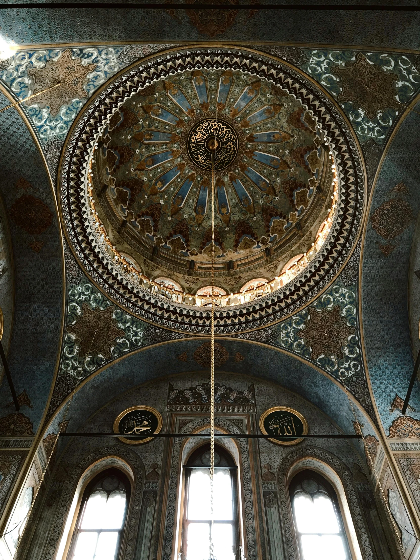 the ceiling of an ornate room has a chandelier