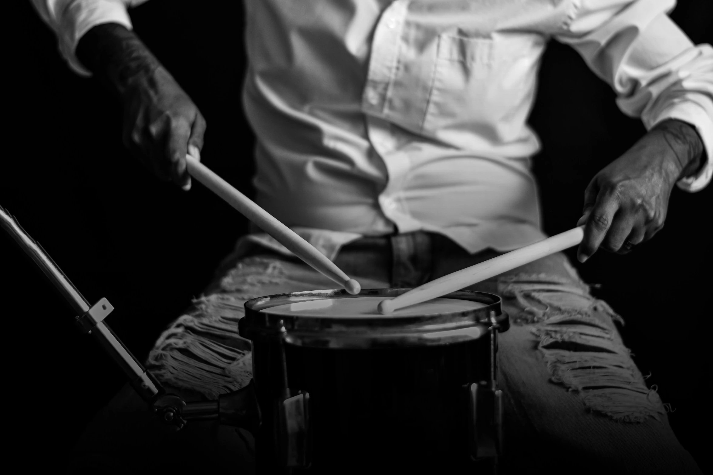 man sitting behind a small table with two drums