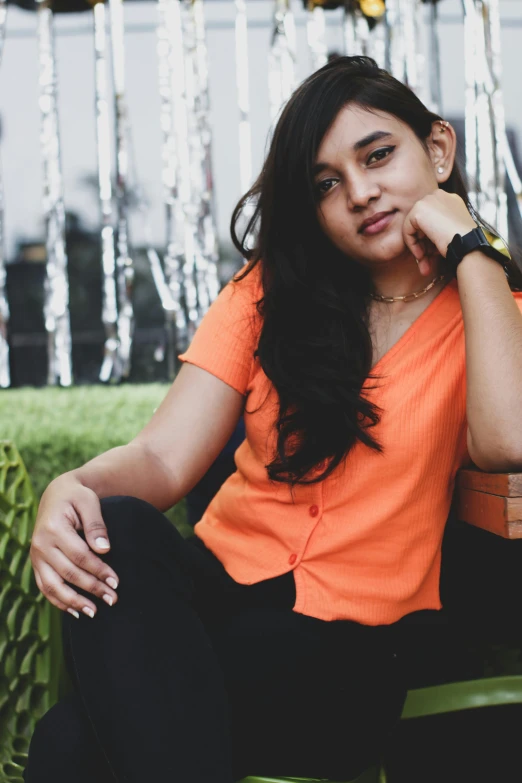 a beautiful young woman sitting on a green chair next to a window