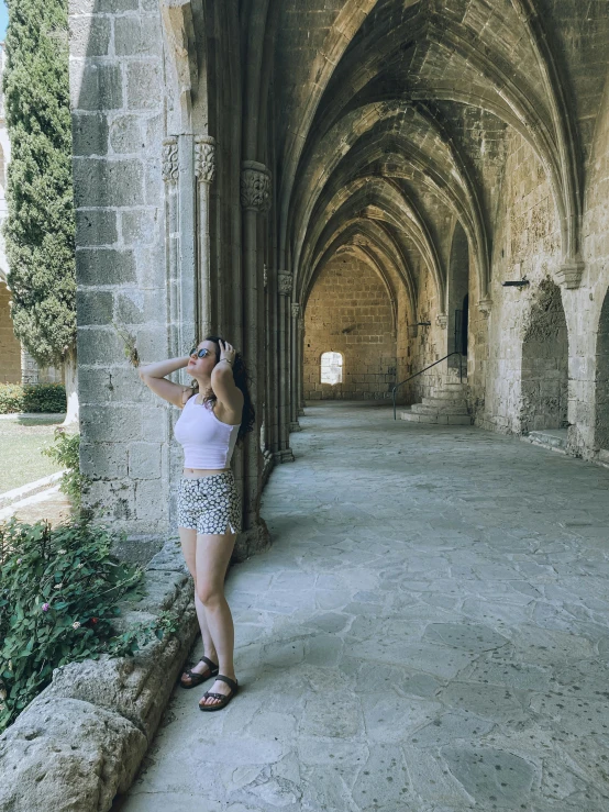 a woman leaning on a stone wall and putting her hand on the water glass