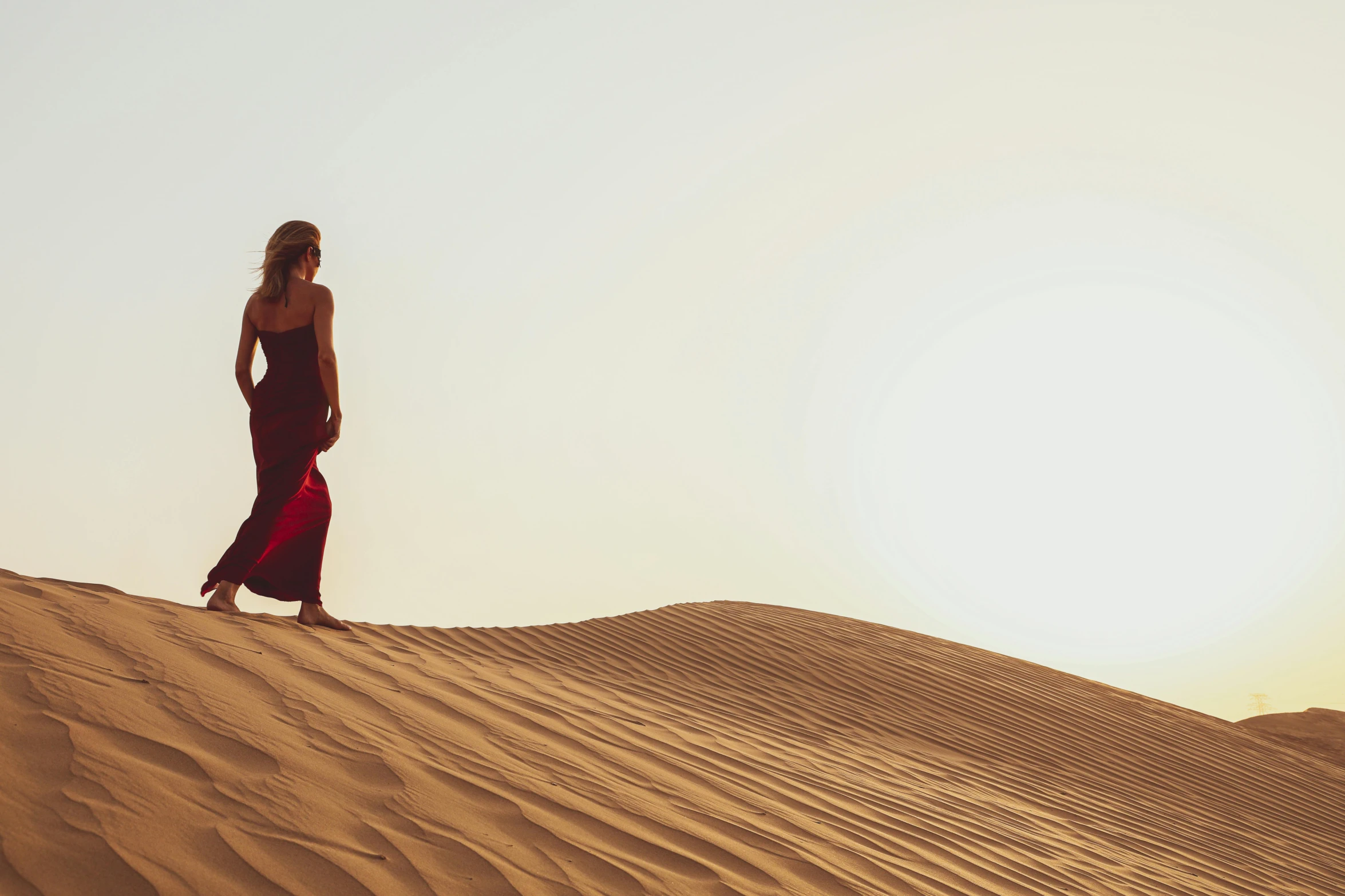 a girl standing on top of sand in the desert