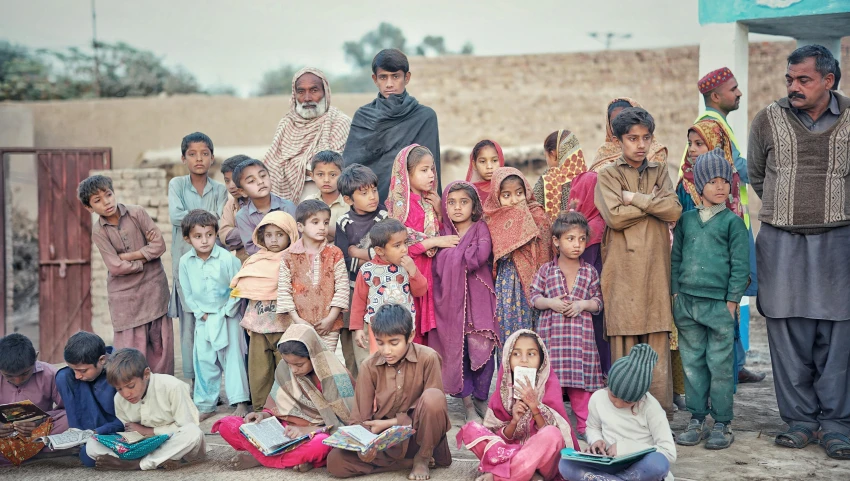 a group of children are sitting together on the ground