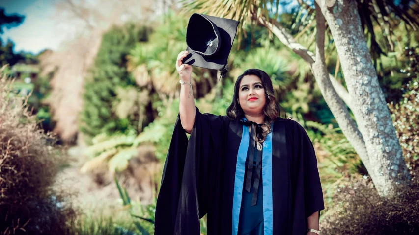 a woman in a black outfit holding a hat