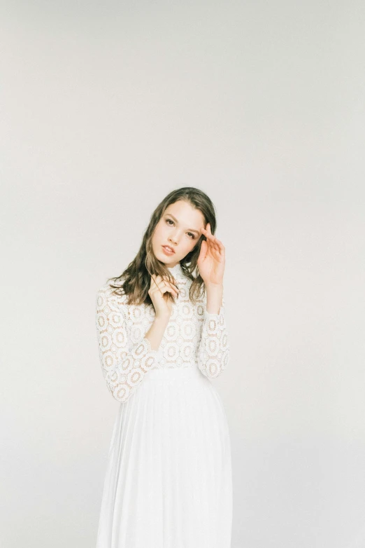 a  poses in a white dress