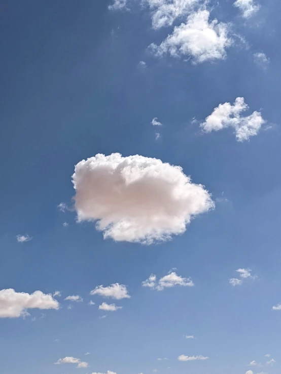 a large cloud hangs from a blue sky
