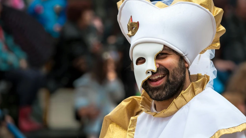 man in white and gold carnival mask on head