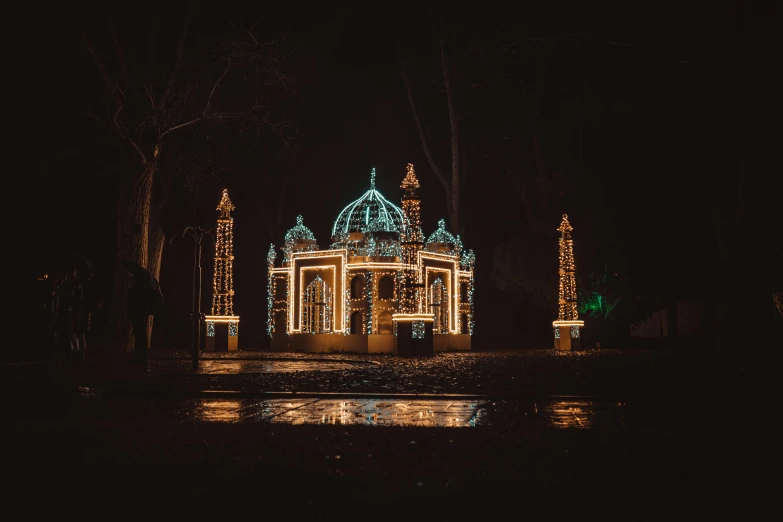 a lit up gazebo that is near some water