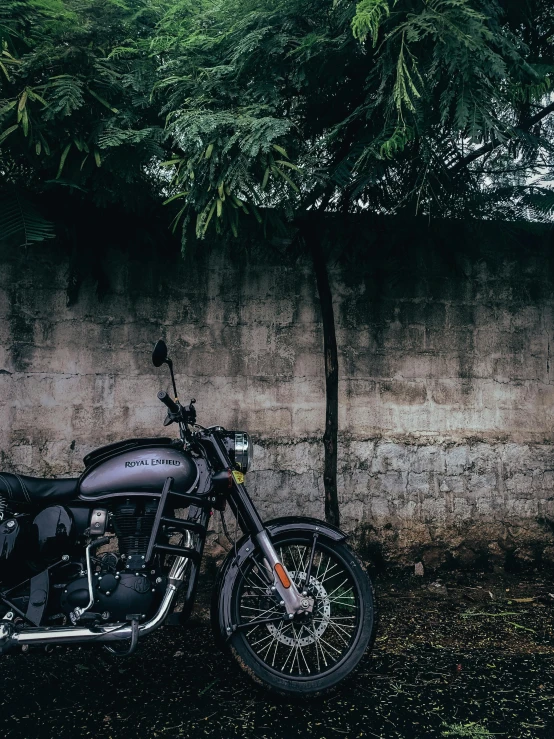 a black motorcycle is parked next to the wall