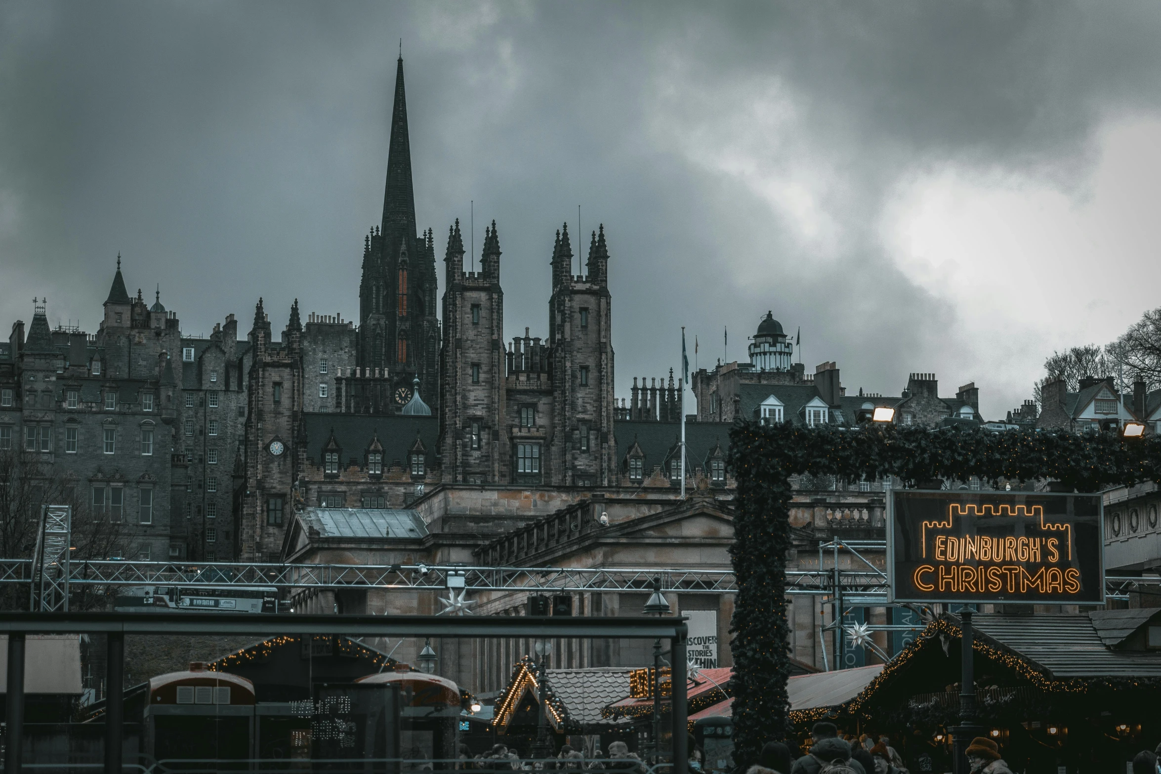 an outdoor christmas market with large cathedrals in the background