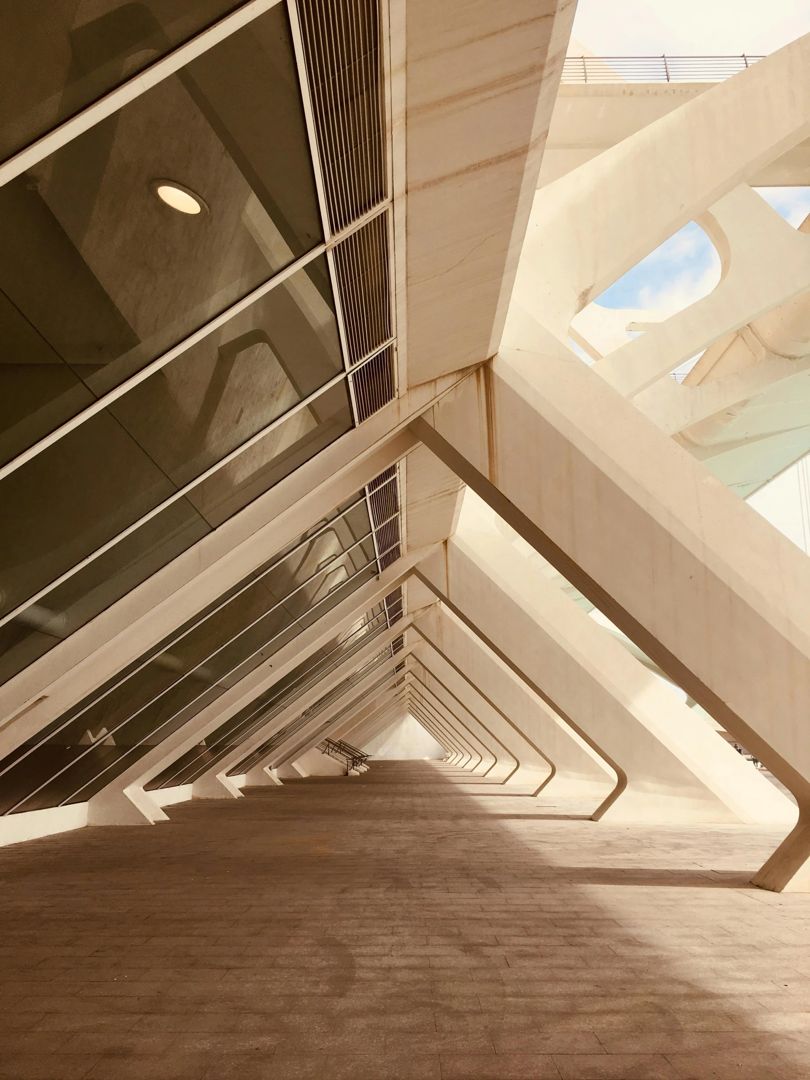 an empty walkway under an overpass with a clock