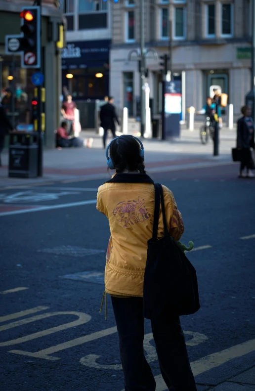 woman with black purse waiting at street corner