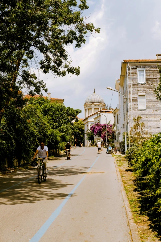 the person is riding his bike down the narrow road