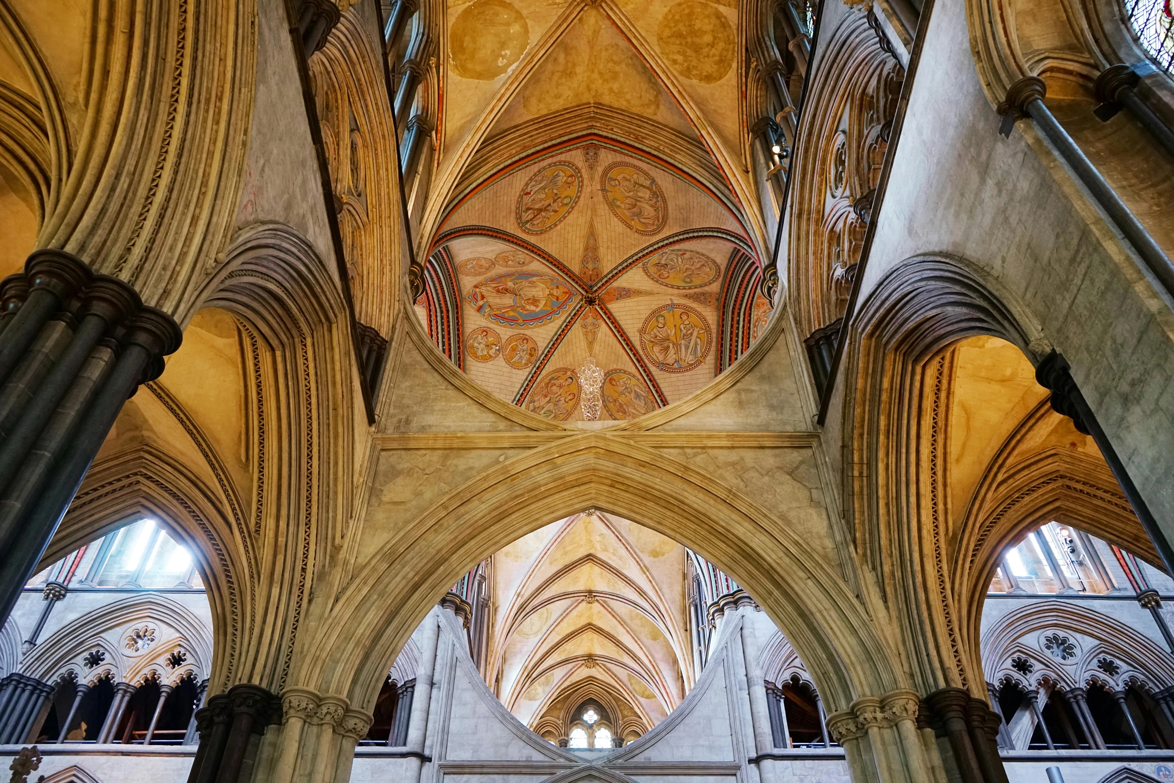 an old cathedral has a vaulted ceiling and a large stained glass window