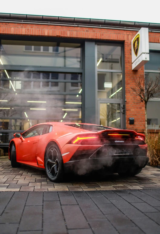 a very shiny orange car on the ground