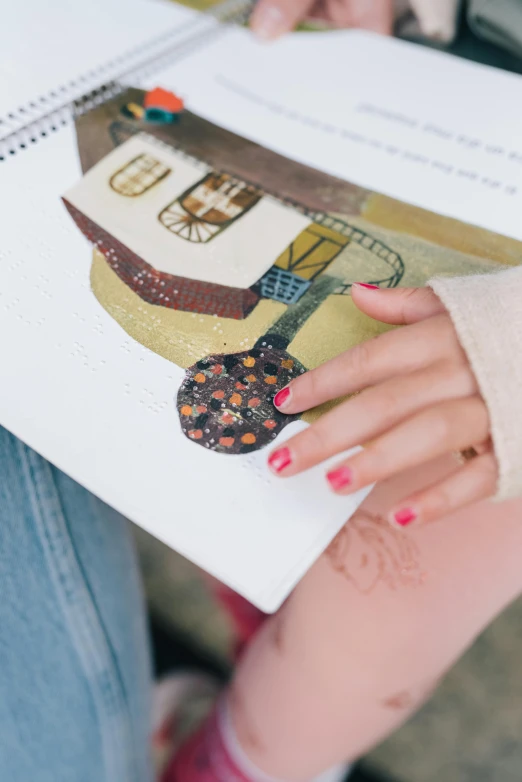 the woman is holding a magazine over her arm