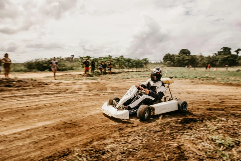 a man is going around in a white dirt car