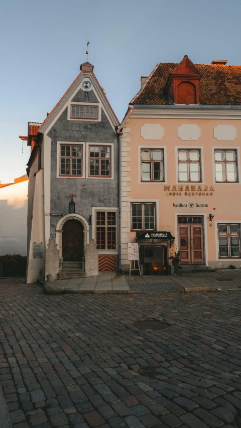 an old building with two story and a weather vane