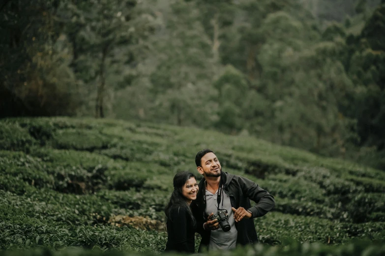 two people in a field with tea bushes