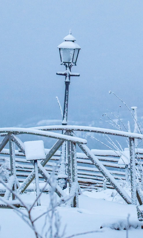 a street light and a snow covered railing