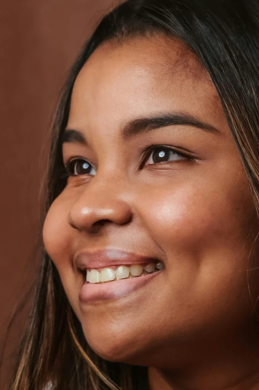 a woman smiling with a cell phone in front of her