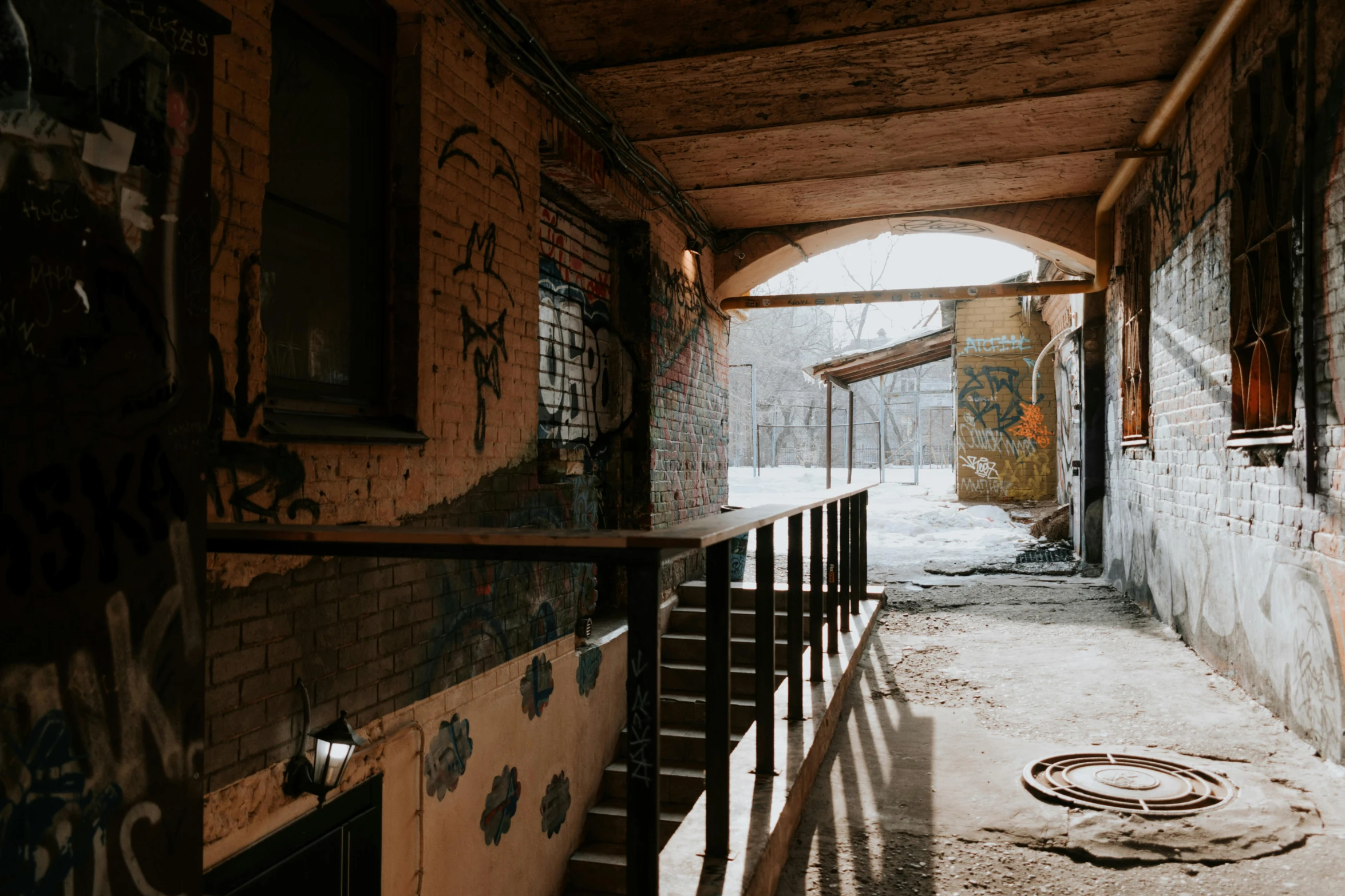 there are graffiti on the walls and floor of an old run down building