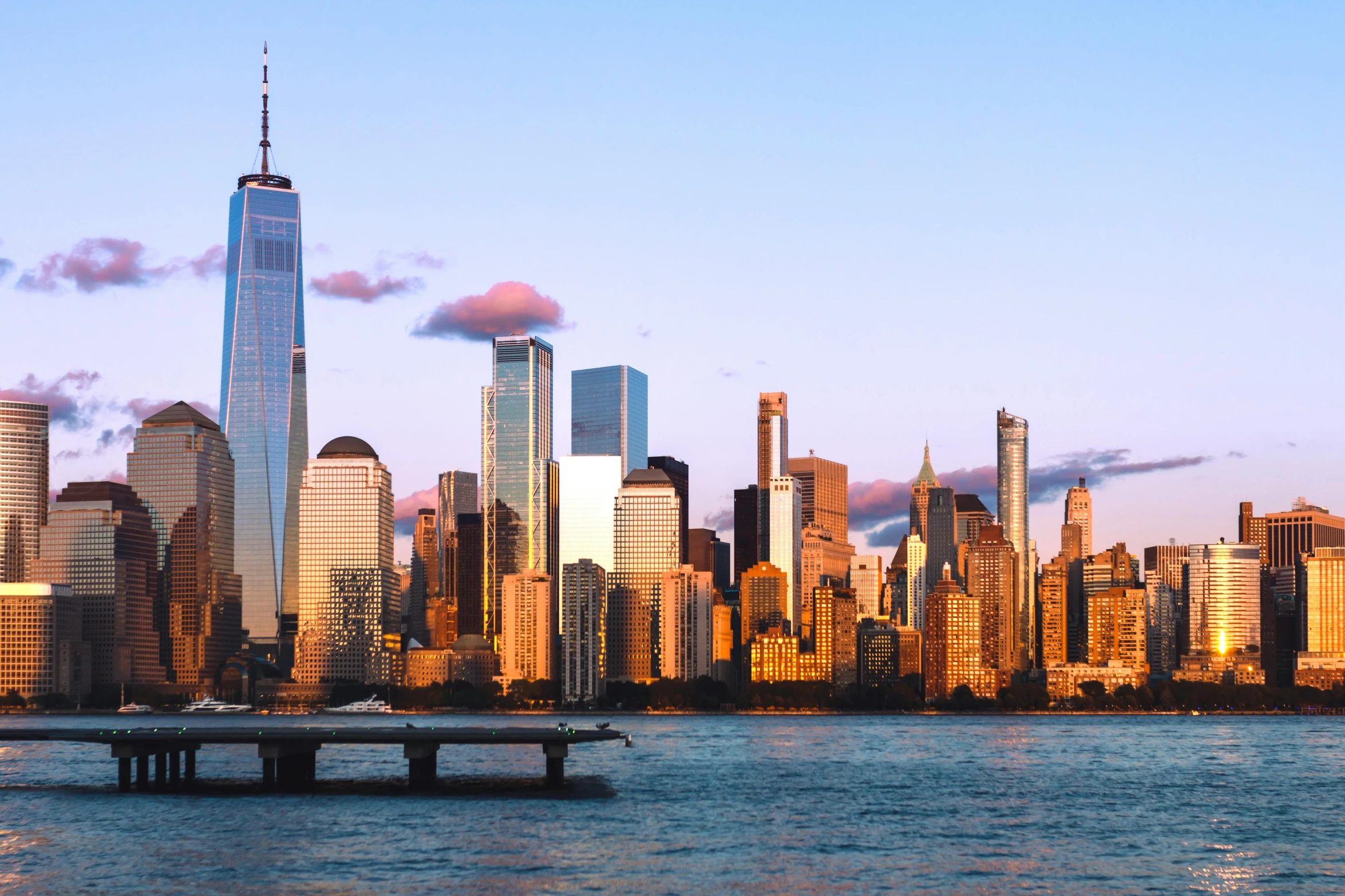 the city skyline is bathed in sunlight while the water reflects it