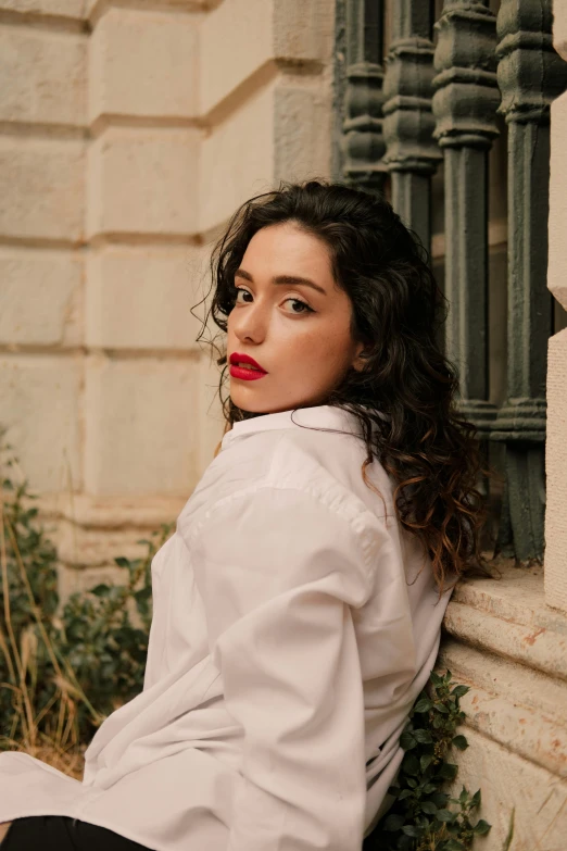 the young woman poses in a white shirt