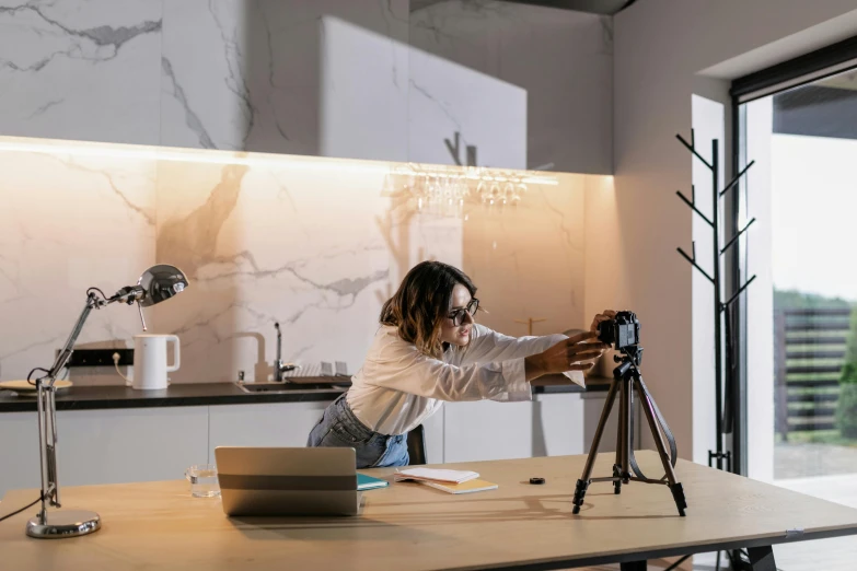 a young woman on a camera recording in front of her laptop