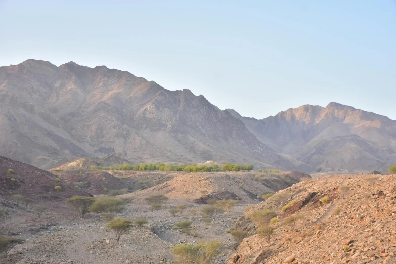 the mountains of a desert area with dirt covered ground