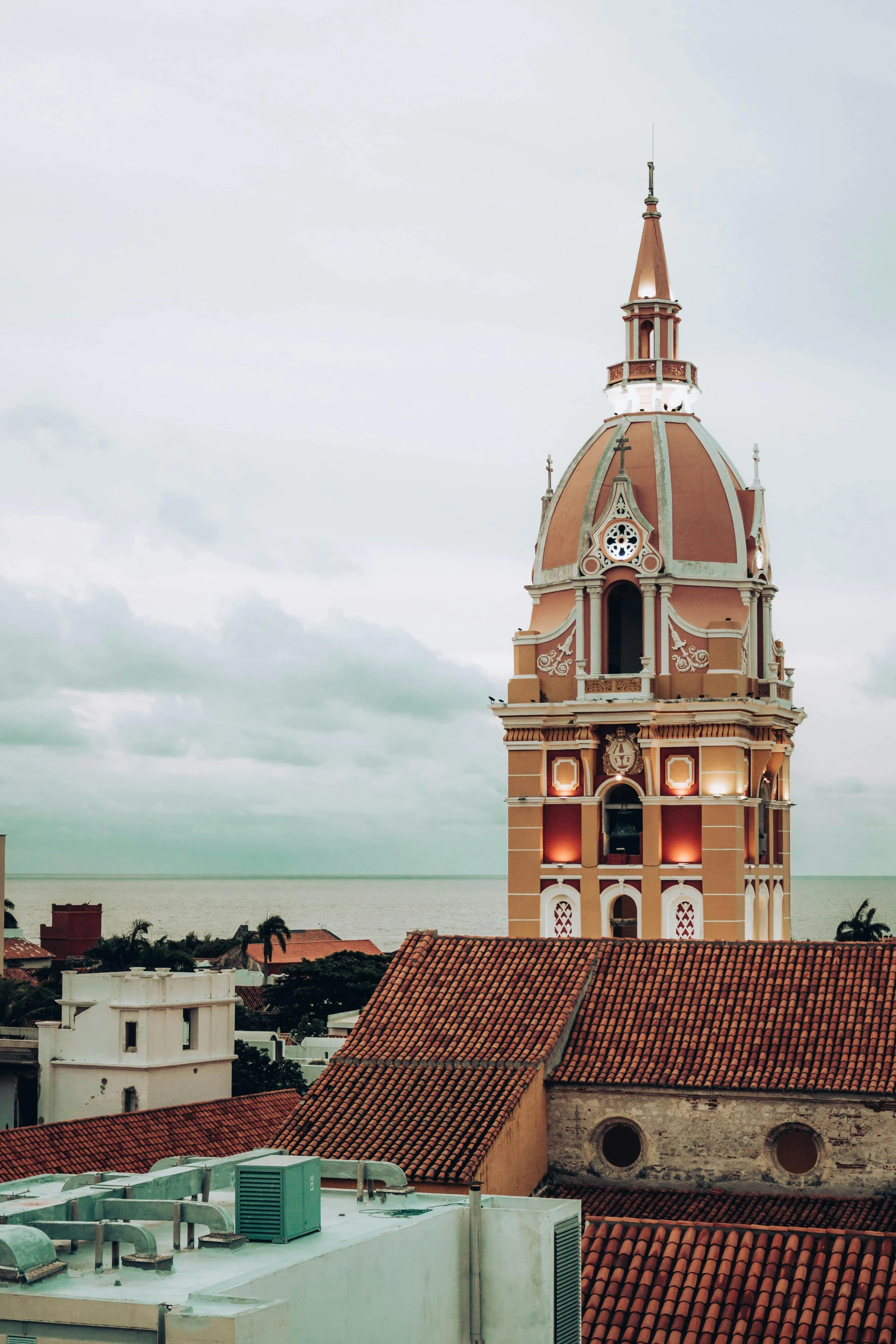 the clock tower is located above the roof tops of many buildings